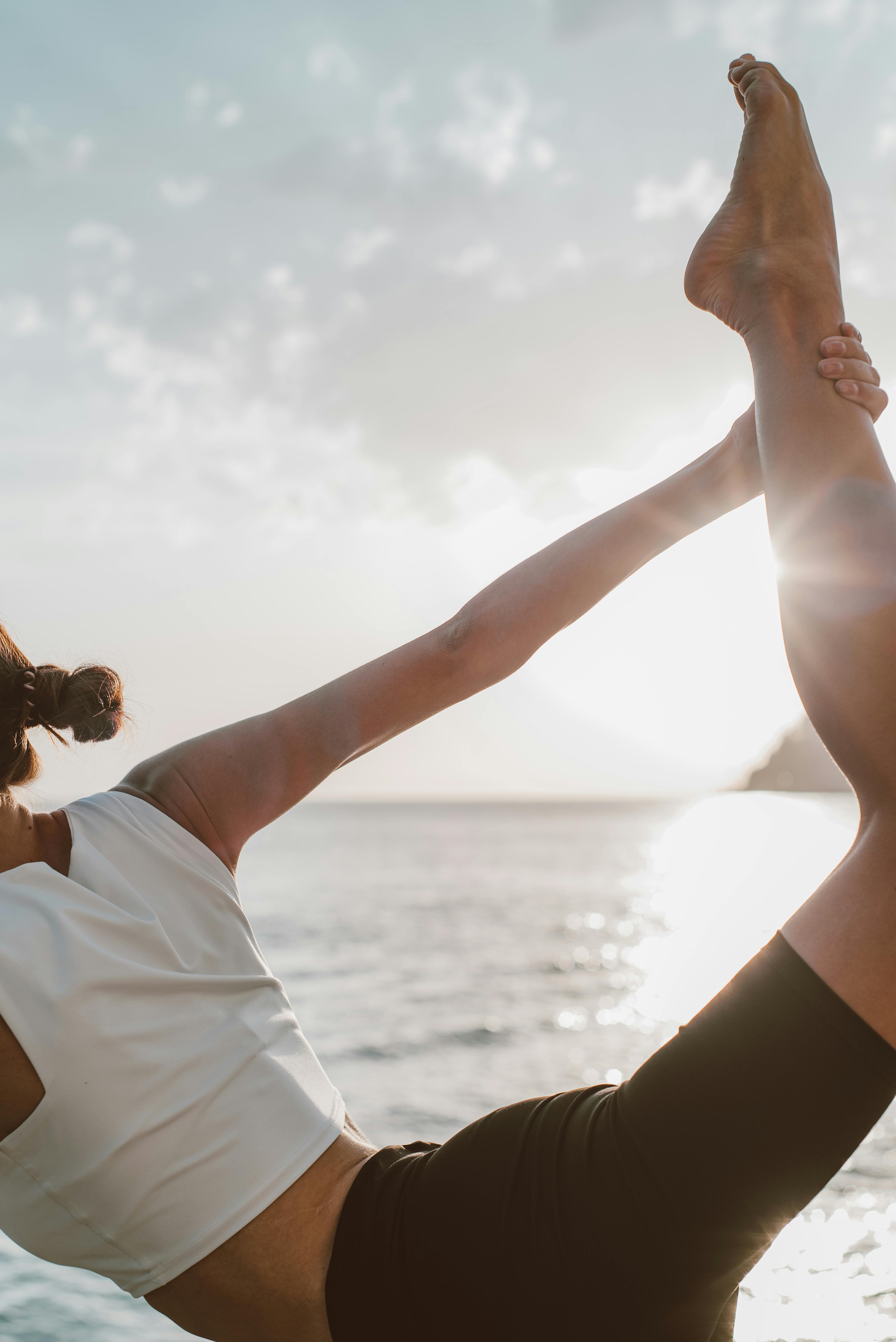 Woman in a peaceful yoga pose at sunset with an amber glow